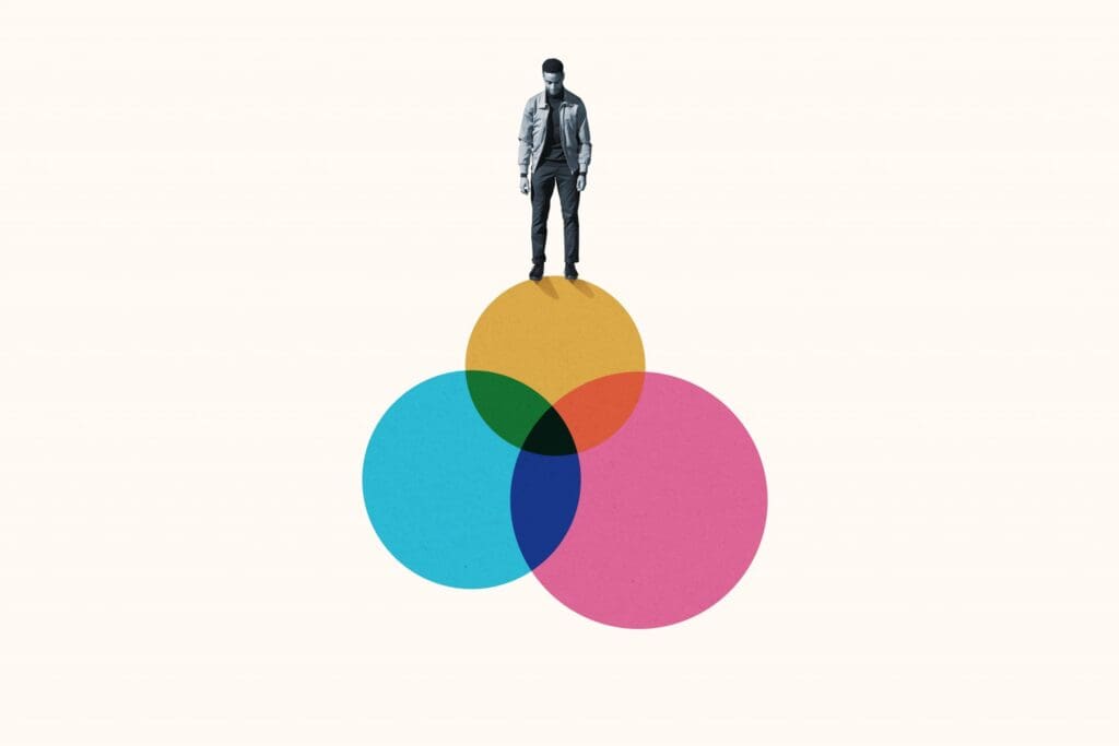 Person standing on overlapping colorful circles (blue, yellow, pink) against a beige background.