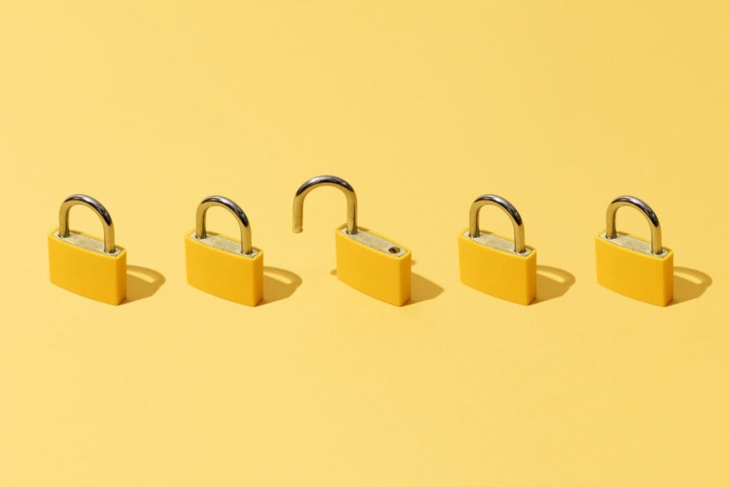 Five yellow padlocks on a matching background; one padlock is open, while the others are closed.