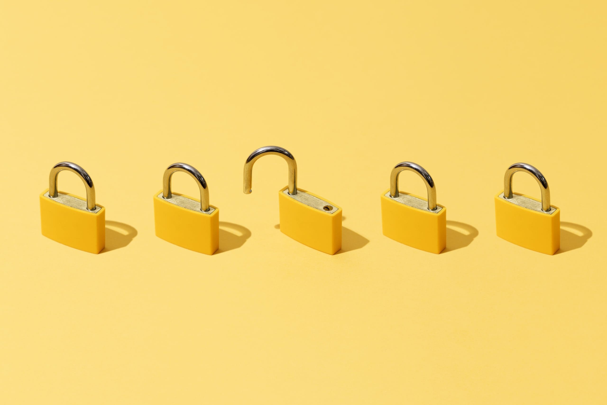 Five yellow padlocks on a matching background; one padlock is open, while the others are closed.