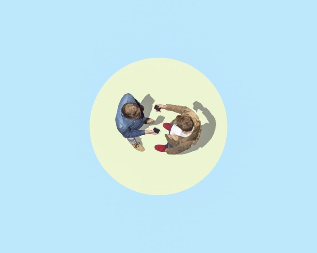 Two people standing in a circle on a blue background, viewed from above.